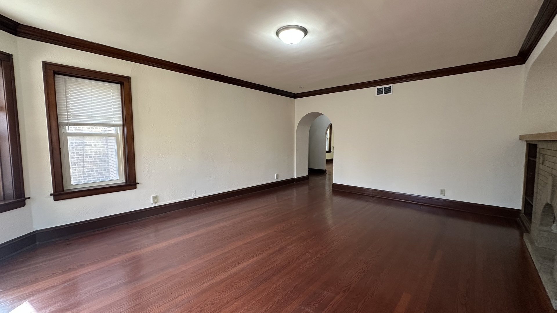 5530 North Artesian Avenue, Unit 3 Chicago, IL 60625 - Photo 4 of 16 a view of an empty room with wooden floor and a window
