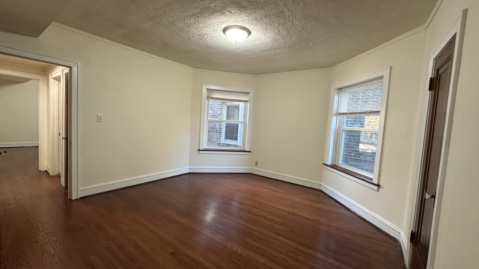 5530 North Artesian Avenue, Unit 3 Chicago, IL 60625 - Photo 5 of 16 an empty room with wooden floor and windows