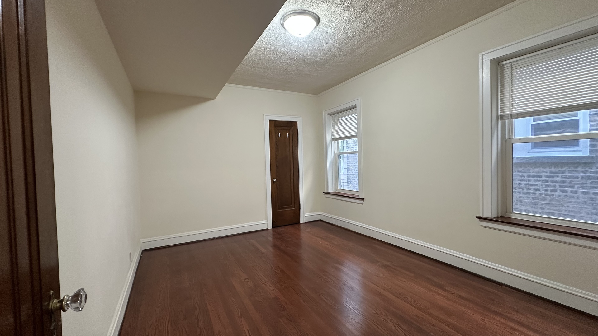 5530 North Artesian Avenue, Unit 3 Chicago, IL 60625 - Photo 8 of 16 an empty room with wooden floor and windows