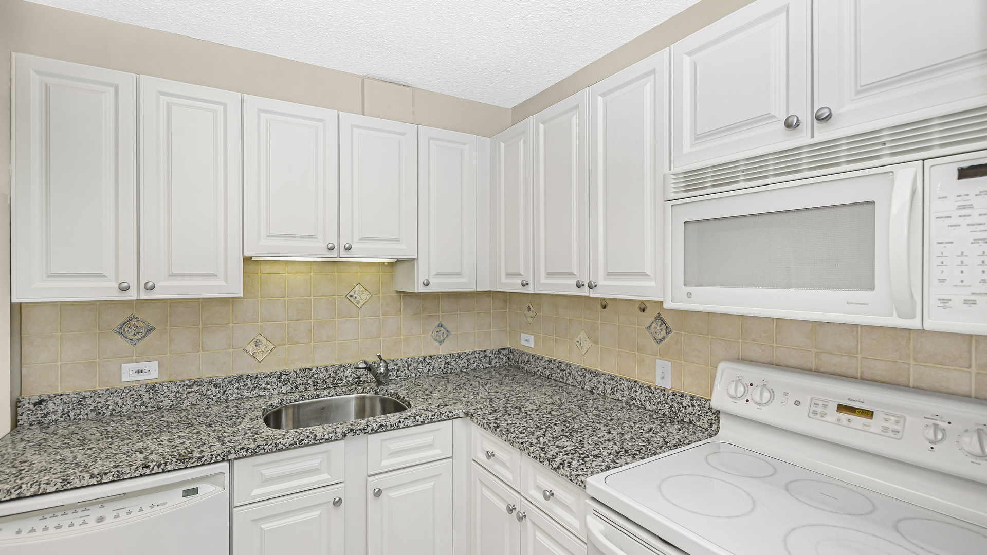 33 West Delaware Place, Unit 10G Chicago, IL 60610 - Photo 5 of 20 a kitchen with stainless steel appliances granite countertop a sink and cabinets with granite countertops