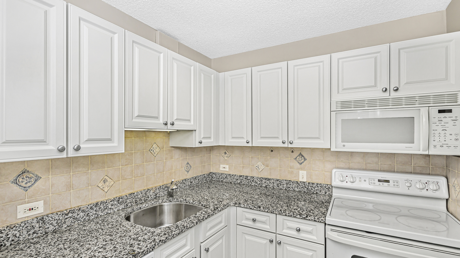33 West Delaware Place, Unit 10G Chicago, IL 60610 - Photo 6 of 20 a kitchen with stainless steel appliances granite countertop white cabinets sink and dishwasher