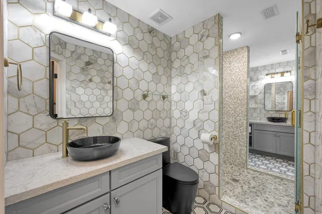 a bathroom with a sink a toilet and shower