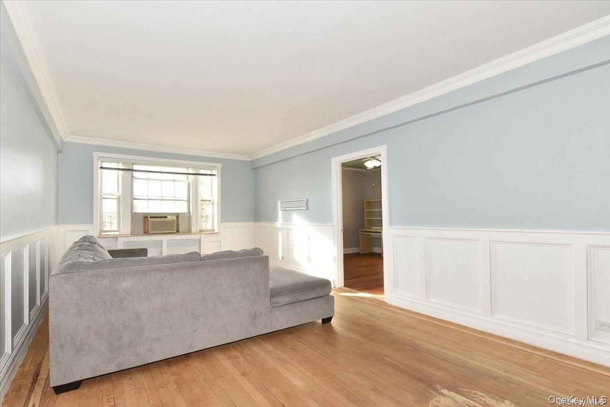 175-06 Devonshire Road, Unit 4M Queens, NY 11432 - Photo 4 of 18 a living room with furniture and a large window