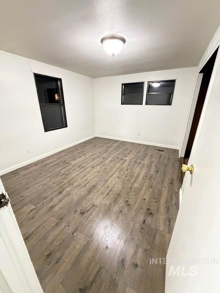 15881 Purple Sage Road, Unit 48 Caldwell, ID 83607 - Photo 11 of 17 Unfurnished room featuring dark wood finished floors and baseboards