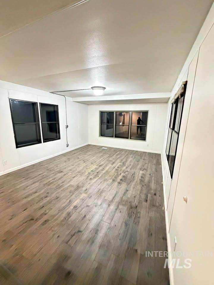 15881 Purple Sage Road, Unit 48 Caldwell, ID 83607 - Photo 12 of 17 Unfurnished room with dark wood-style flooring and baseboards