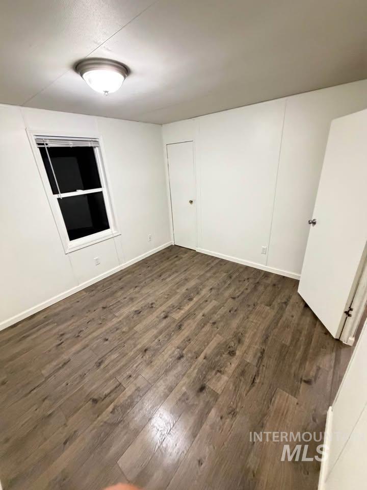 15881 Purple Sage Road, Unit 48 Caldwell, ID 83607 - Photo 15 of 17 Unfurnished room featuring dark wood-style flooring and baseboards