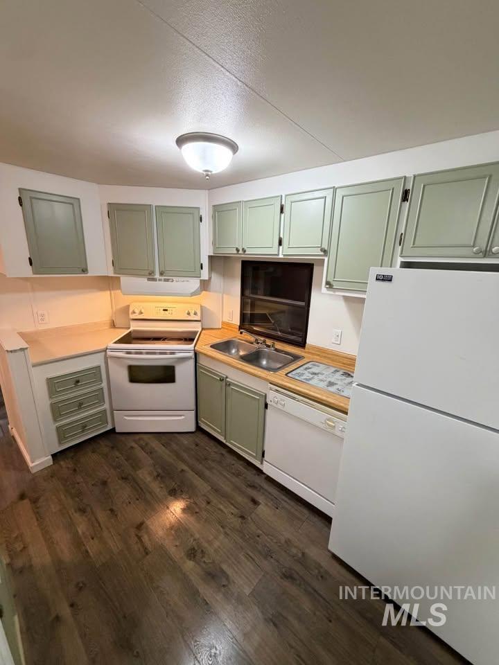 15881 Purple Sage Road, Unit 48 Caldwell, ID 83607 - Photo 2 of 17 Kitchen featuring green cabinetry, white appliances, light countertops, and dark wood finished floors