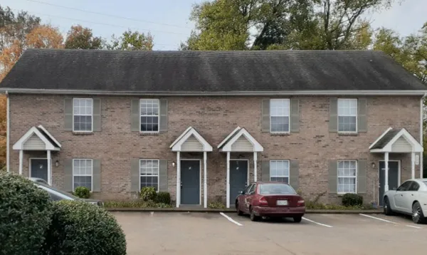 a front view of a house with cars parked