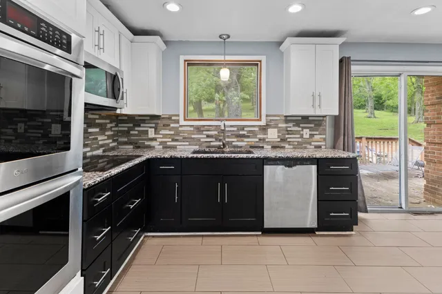 a bathroom with a granite countertop toilet sink and mirror