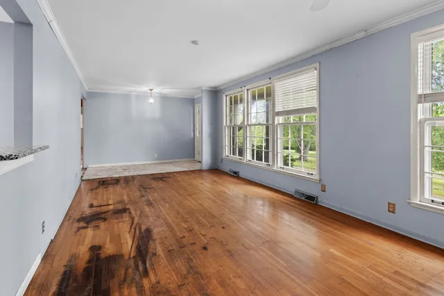 a view of a hallway with wooden floor and a window