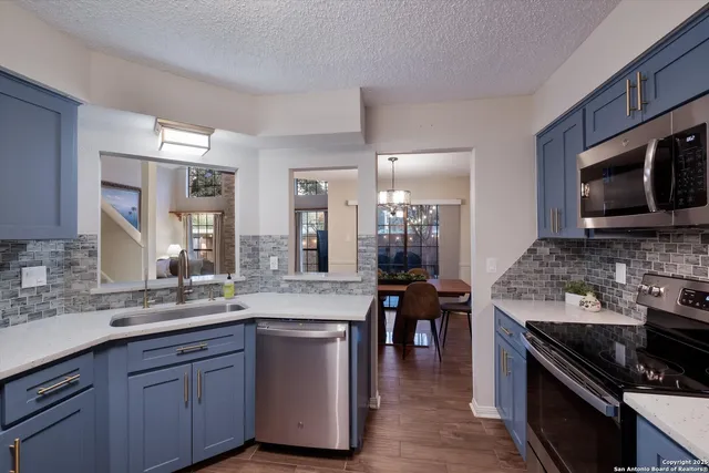 a spacious kitchen with stainless steel appliances granite countertop a stove and a sink