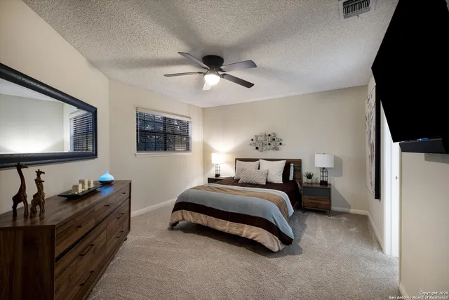 a spacious bedroom with a bed and a flat screen tv