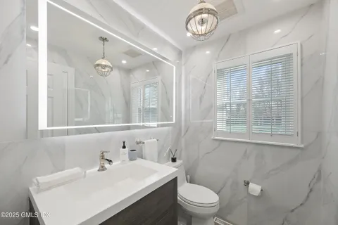 a bathroom with a sink a toilet and a mirror