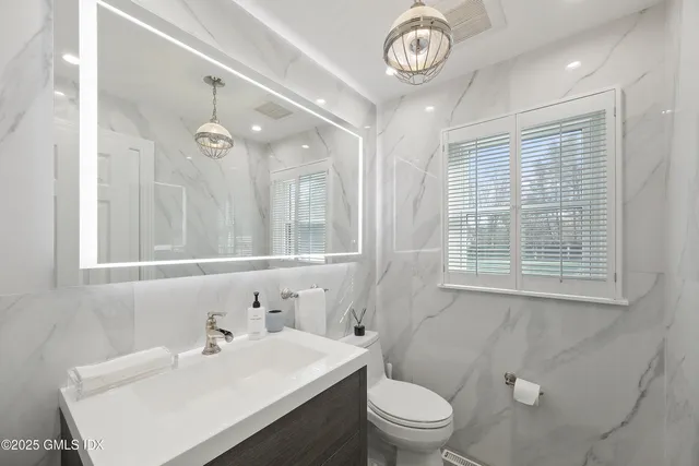 a bathroom with a sink a toilet and a mirror