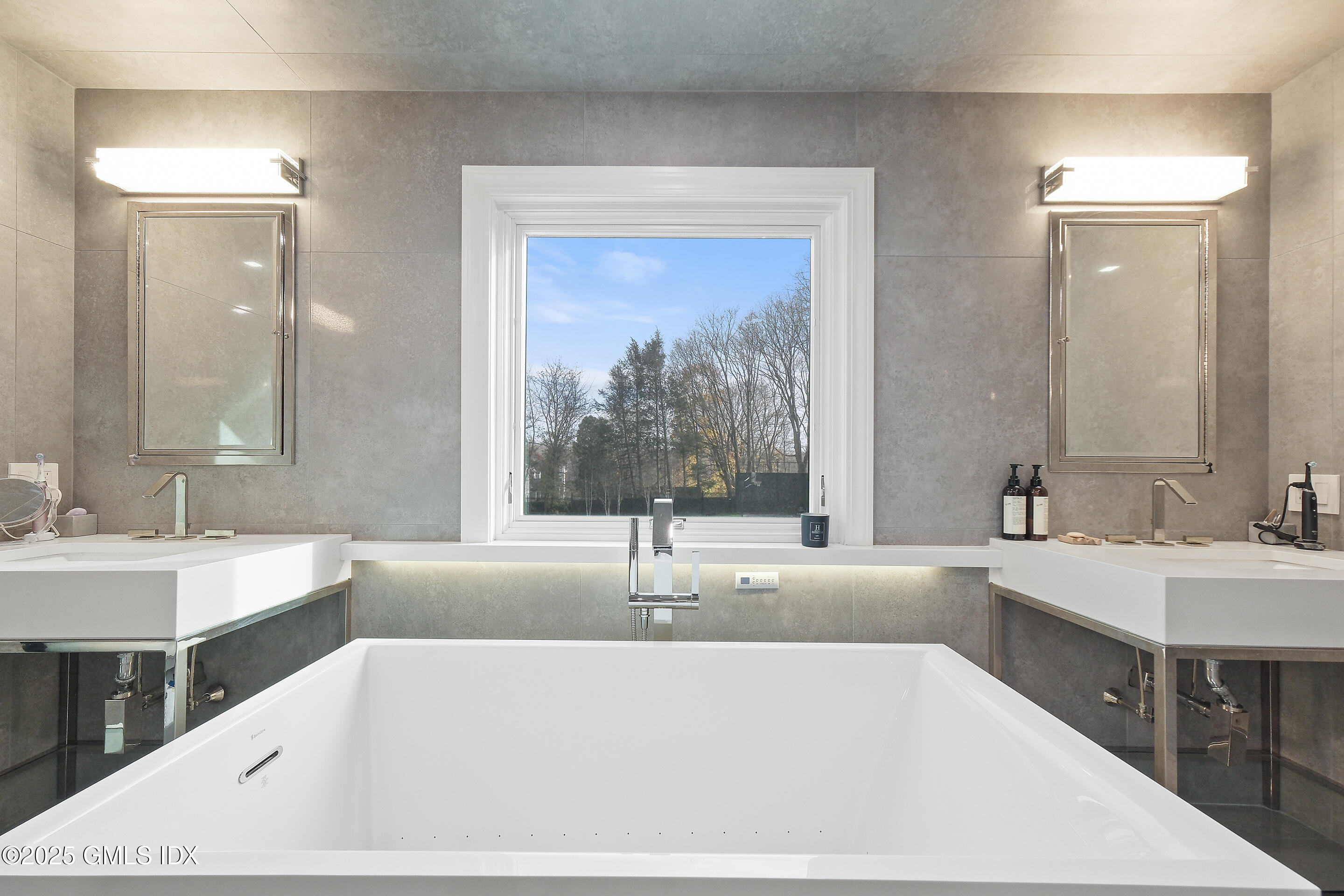 4 Banksville Avenue Greenwich, CT 06831 - Photo 23 of 37 a bathroom with a bathtub a double vanity sink and mirror