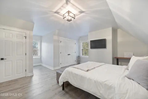 a spacious bedroom with a bed and a flat screen tv