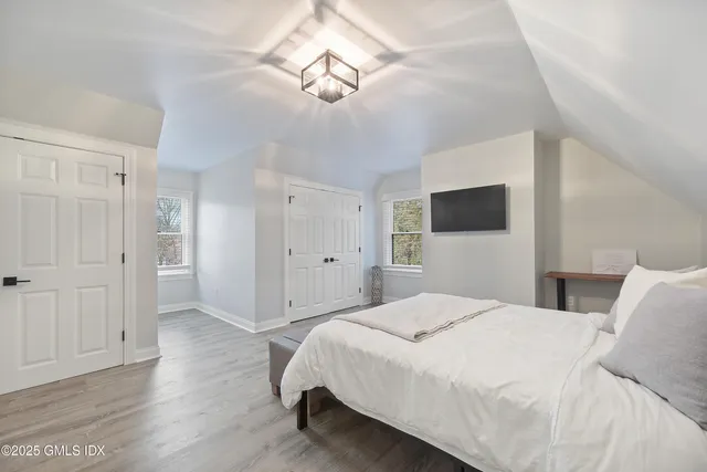 a spacious bedroom with a bed and a flat screen tv