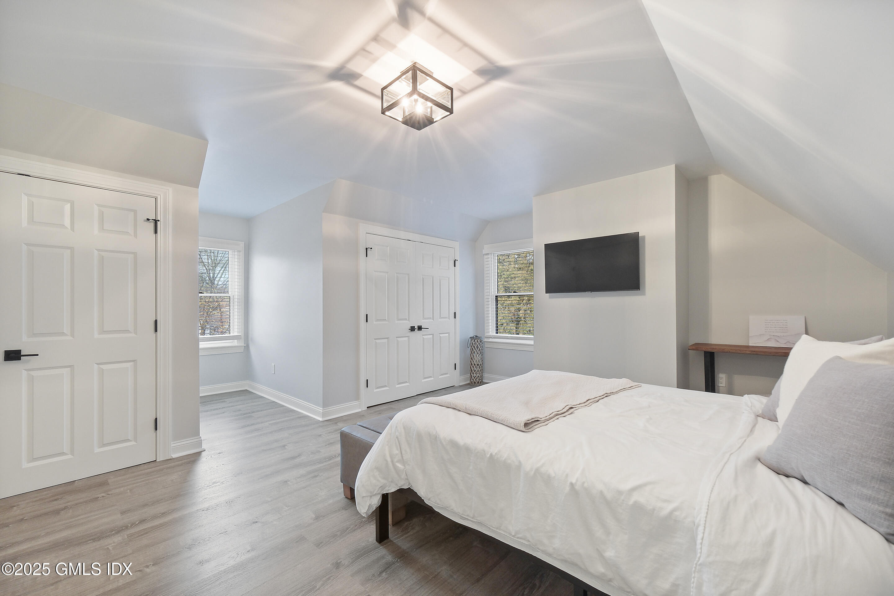 4 Banksville Avenue Greenwich, CT 06831 - Photo 27 of 37 a spacious bedroom with a bed and a flat screen tv