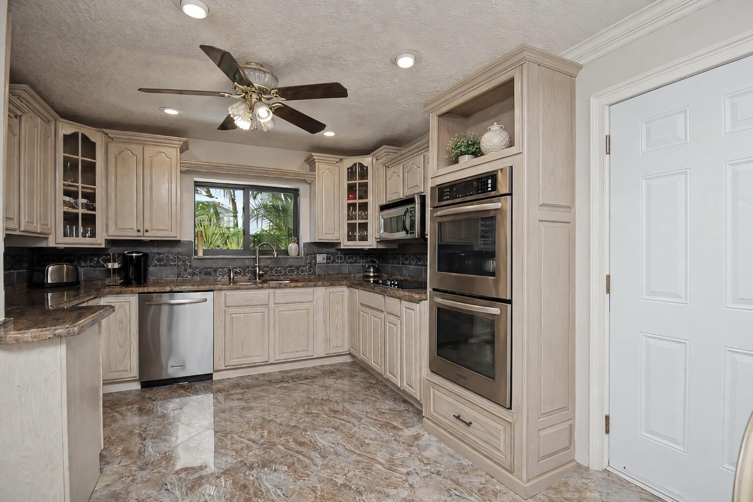 9708 Erica Court Boca Raton, FL 33496 - Photo 24 of 54 a kitchen with stainless steel appliances a refrigerator sink and microwave