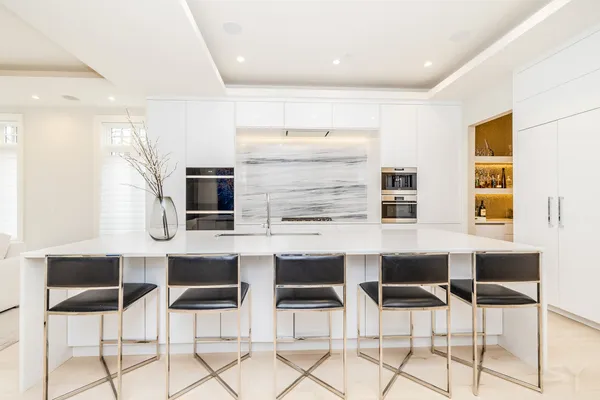 a kitchen with stainless steel appliances kitchen island granite countertop a table and chairs in it