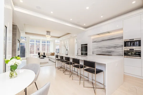 a room with stainless steel appliances kitchen island granite countertop furniture and a large window