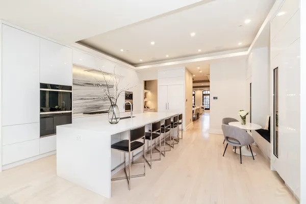 a large white kitchen with furniture and a refrigerator