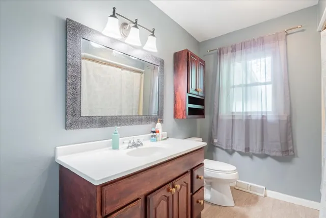 a bathroom with a sink vanity toilet and shower