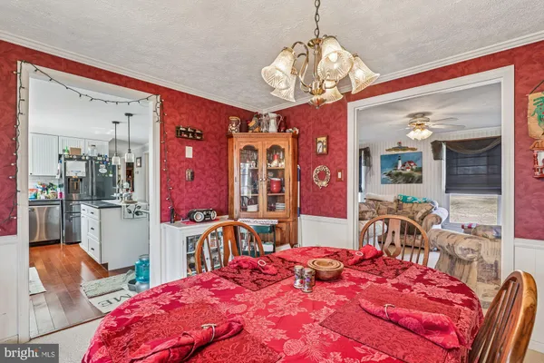 a bedroom with a bed a chandelier and dresser