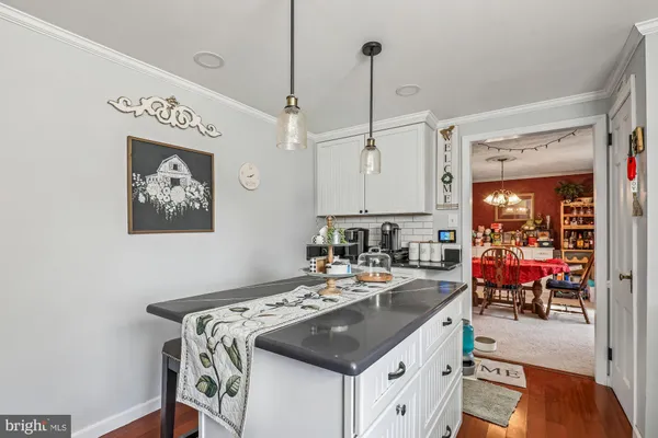 a kitchen with a table chairs microwave and cabinets