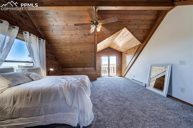 19350 Lemesany Road Calhan, CO 80808 - Photo 36 of 46 Master bedroom featuring baseboard heating, wooden ceiling, vaulted ceiling, walk out to balcony, and walk in closet