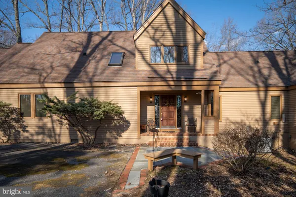 a dining room with furniture a chandelier and wooden floor