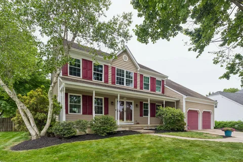 a front view of a house with a yard and potted plants
