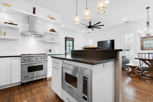 a kitchen with kitchen island a stove a sink and a microwave