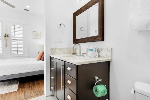 a en suite bathroom with a granite countertop sink and a mirror