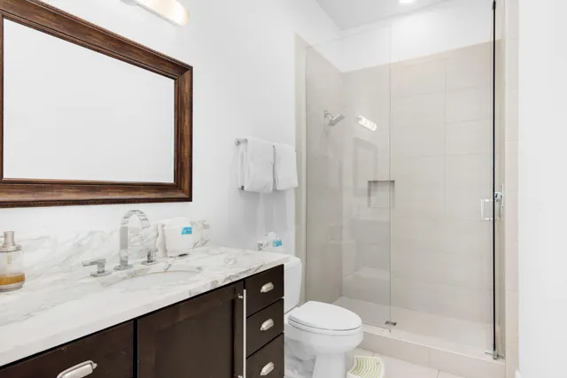 a bathroom with a sink a toilet and shower