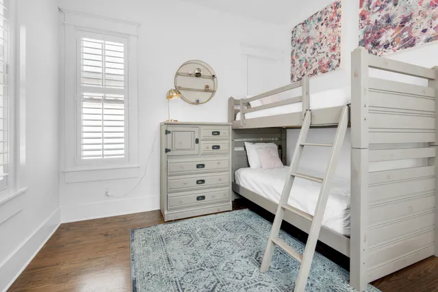 a bedroom with a bunk bed and a window