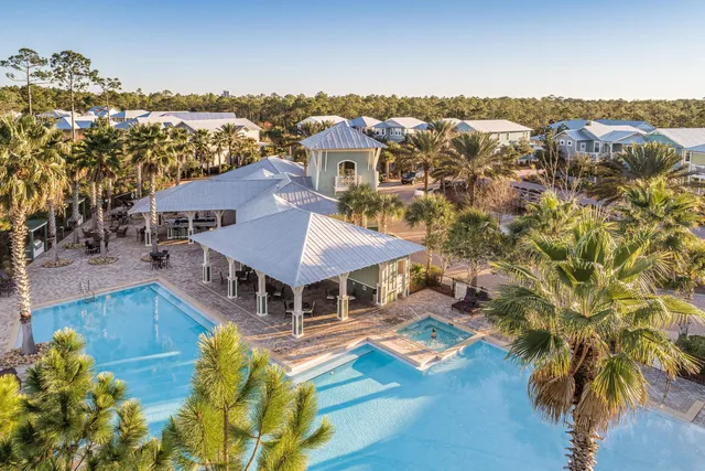 an aerial view of a house with swimming pool and mountains