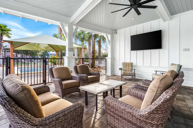 a living room with furniture a flat screen tv and a floor to ceiling window