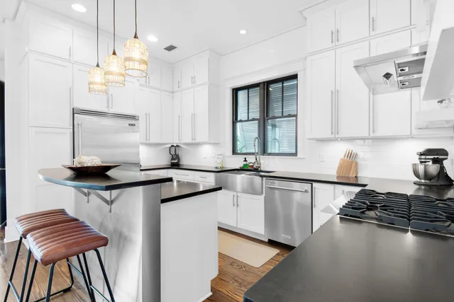 a kitchen with granite countertop a stove a sink and a refrigerator