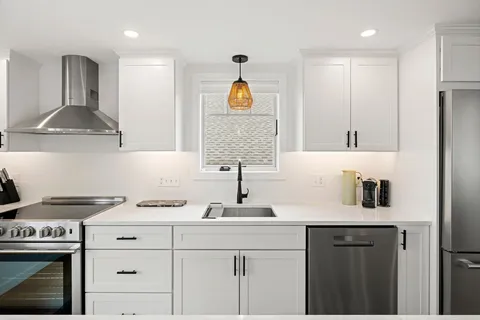 a large kitchen with a sink a counter space cabinets and appliances