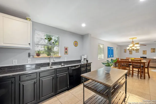 a kitchen with a stove a sink a dining table and chairs