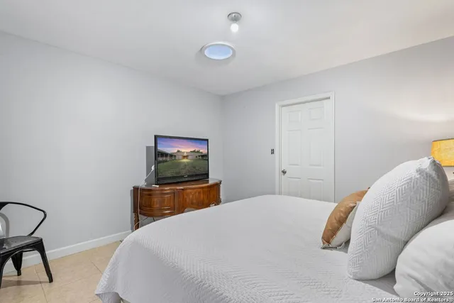 a bedroom with a bed and a flat screen tv