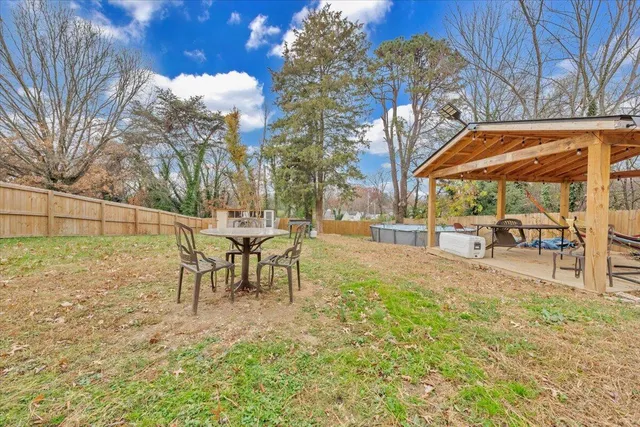 a backyard of a house with table and chairs