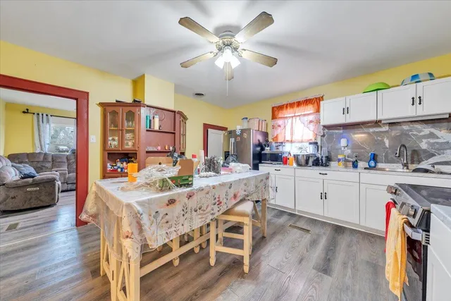 a kitchen with stainless steel appliances white cabinets and wooden floors