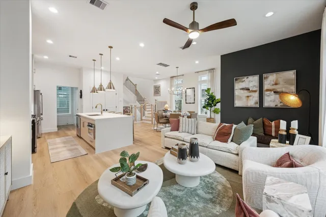a living room with furniture kitchen view and a chandelier