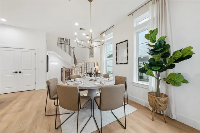 a view of a dining room with furniture a potted plant and wooden floor