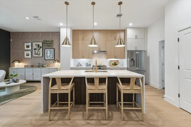 a kitchen with kitchen island stainless steel appliances a dining table and chairs