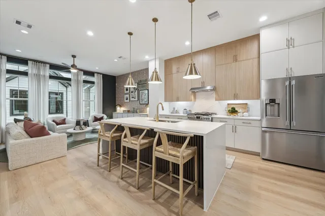 a kitchen with a refrigerator a oven and white cabinets