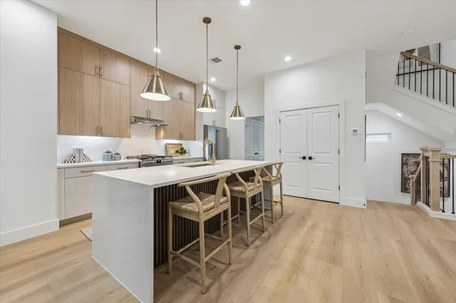 a kitchen with kitchen island granite countertop a sink cabinets and stainless steel appliances