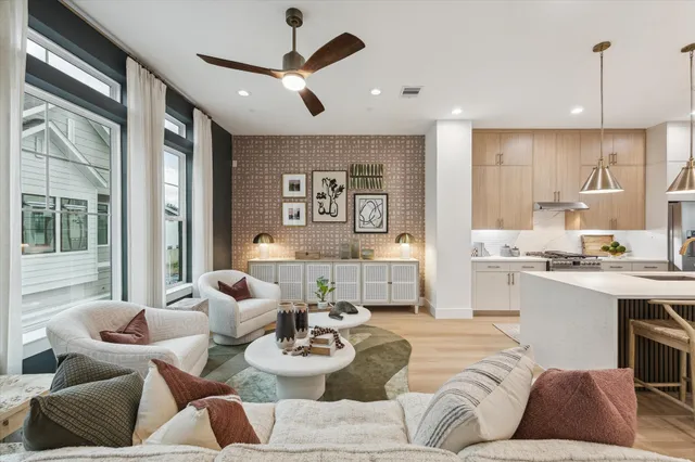 a living room with furniture kitchen view and a large window